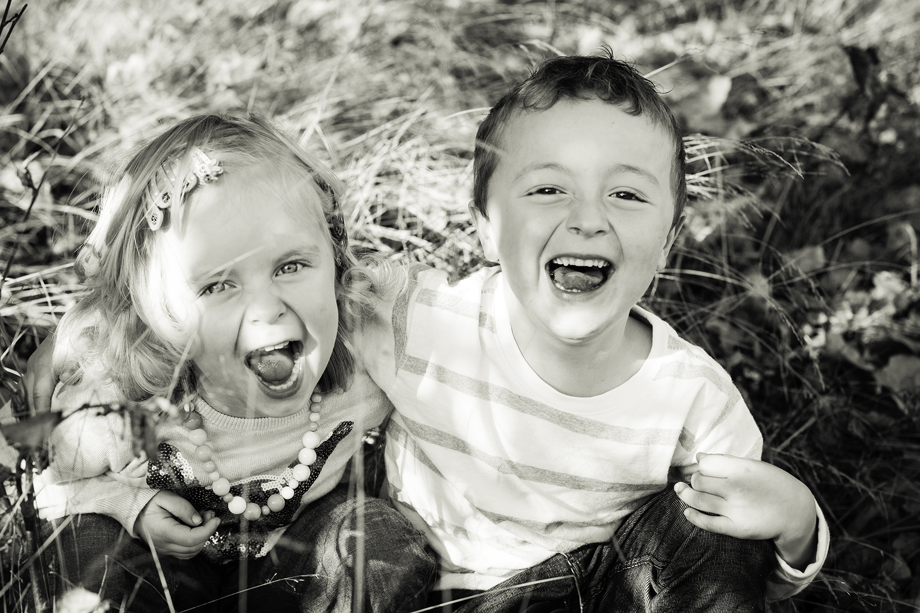 "Laughing siblings at a family photoshoot."