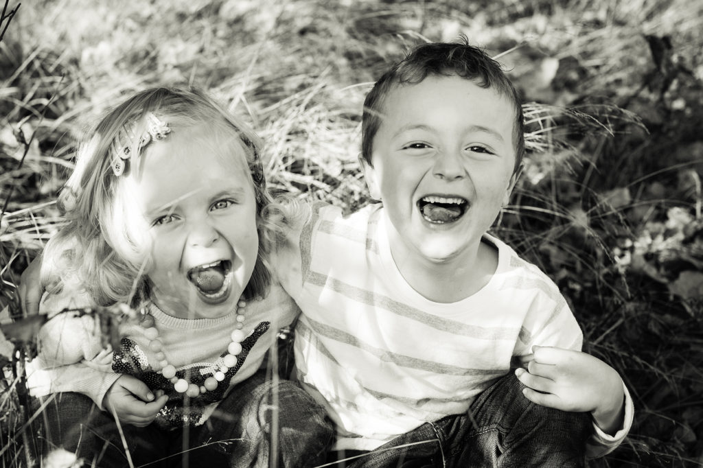 "Laughing siblings at a family photoshoot."