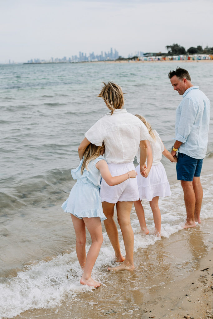 Family standing at the beach during a Bayside mini session photoshoot in Melbourne.